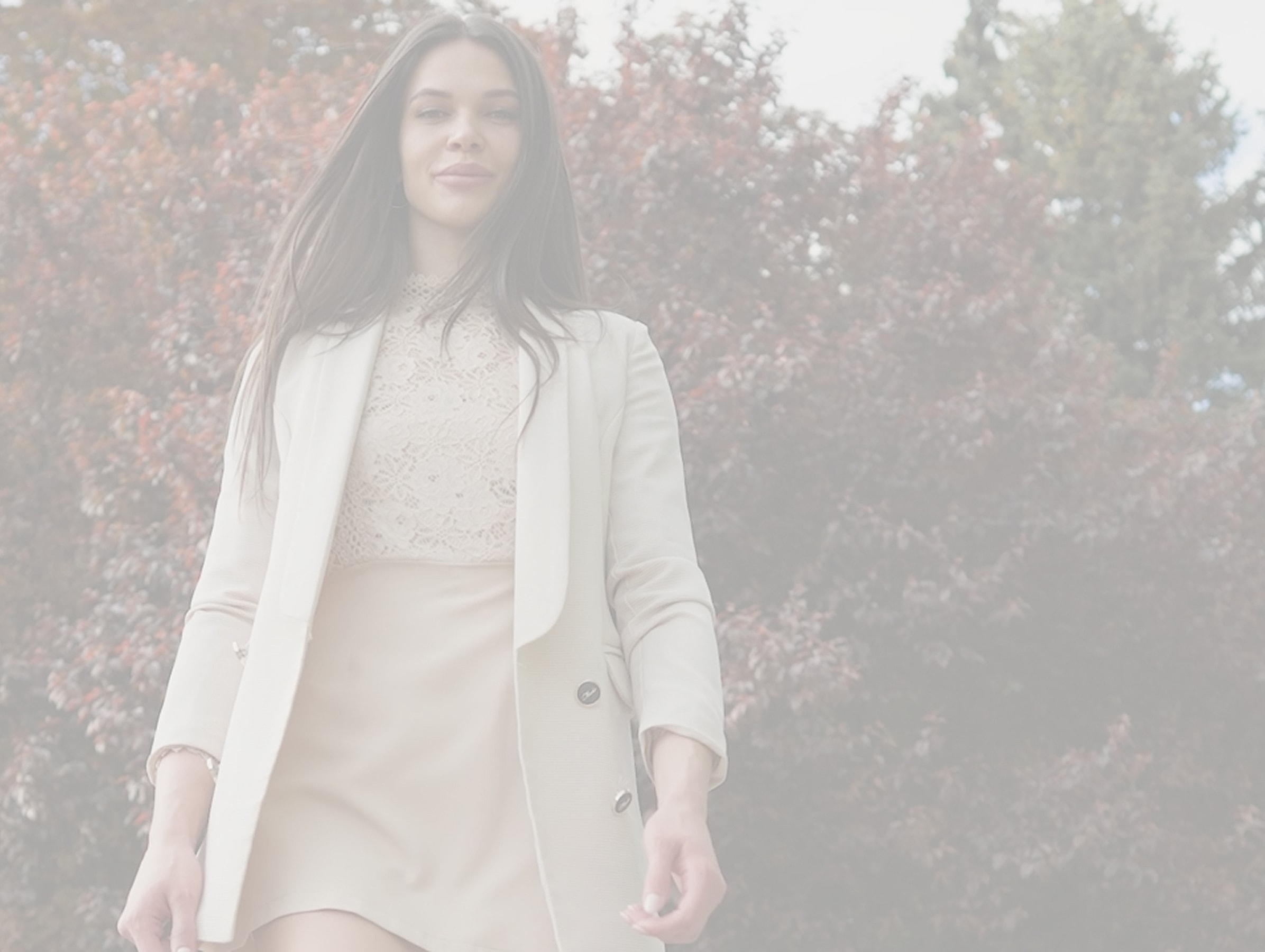 Woman in stylish outfit outdoors, autumn backdrop.