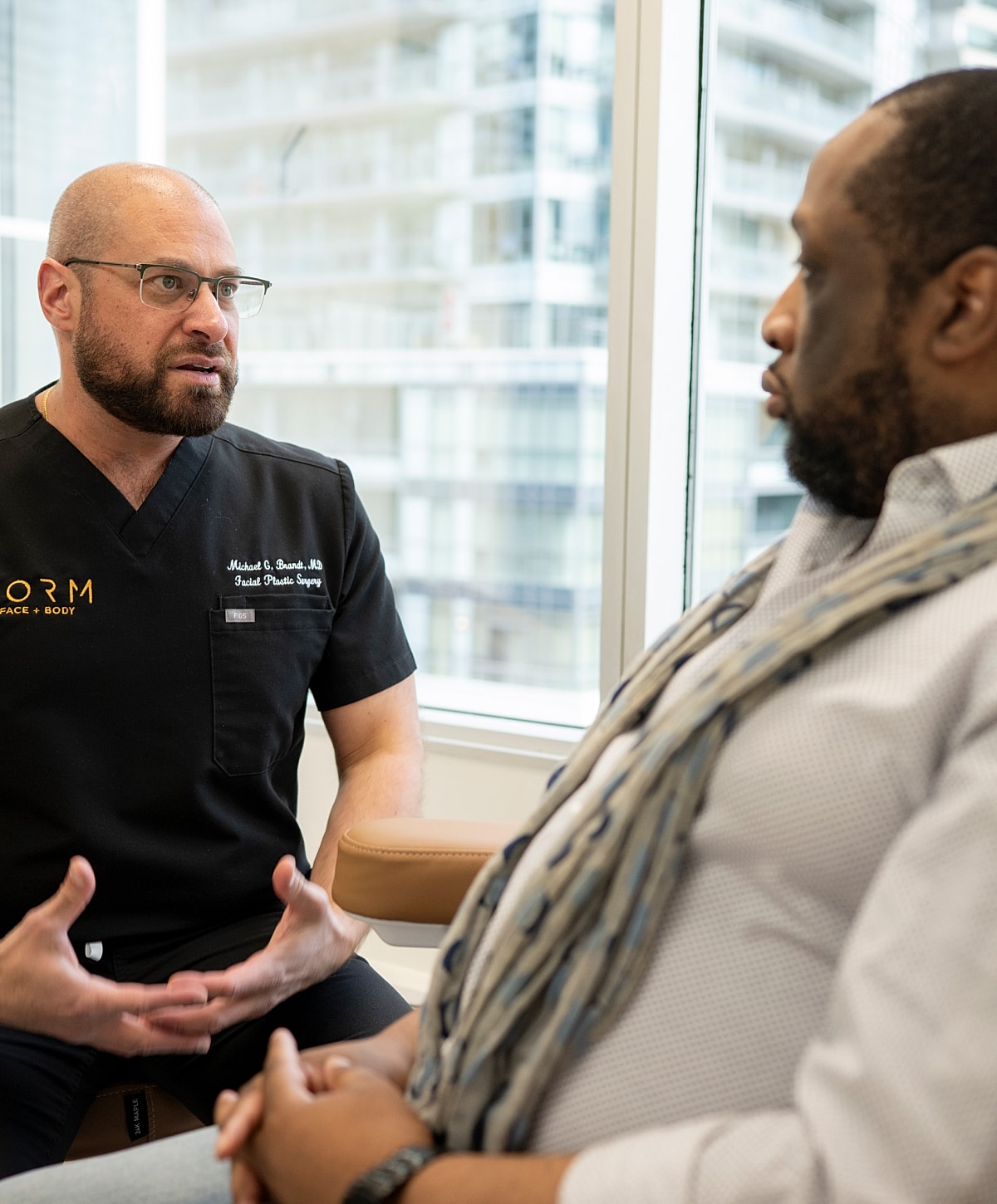 Doctor consults patient in medical office setting.