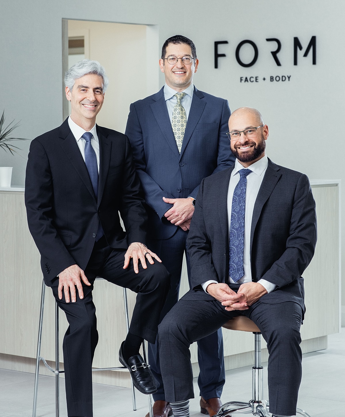 Three professionals posing in a modern office.