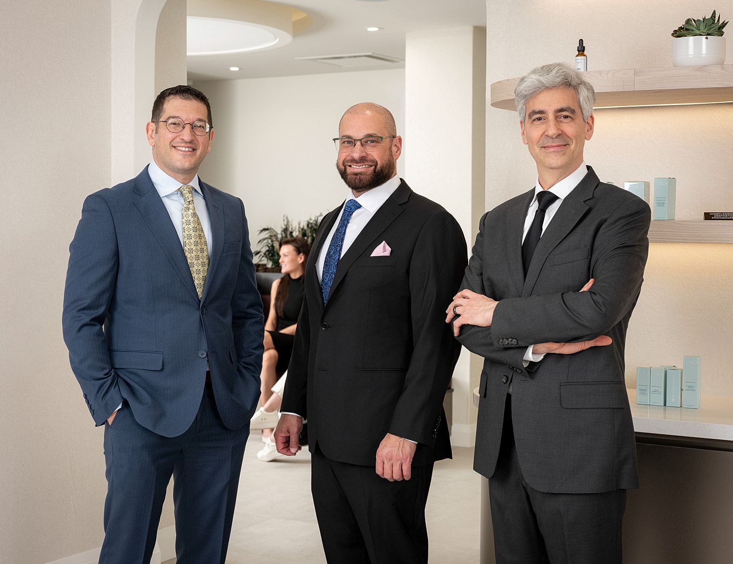 Three professionals standing in a modern office.