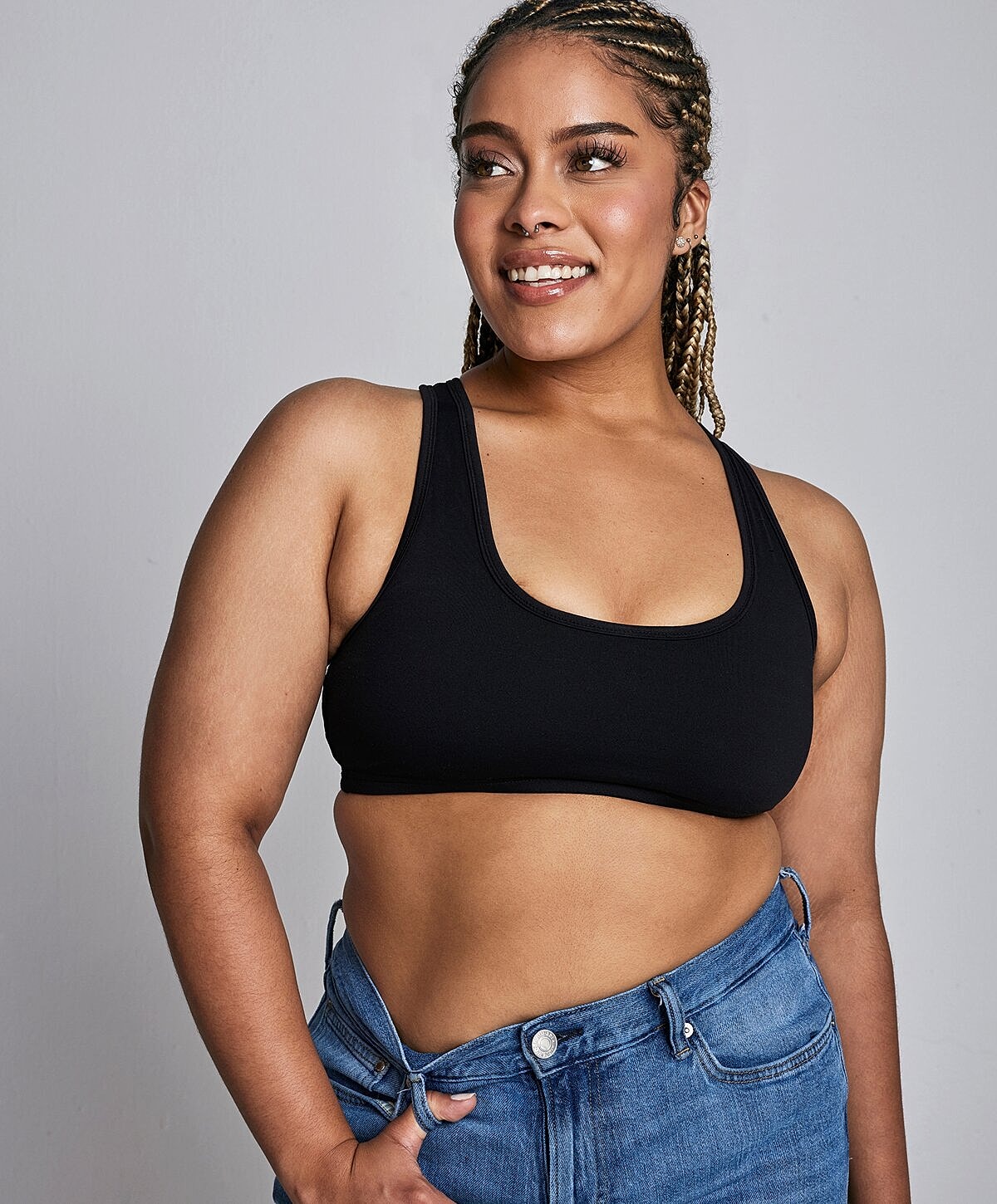 Smiling woman in black top and denim shorts.