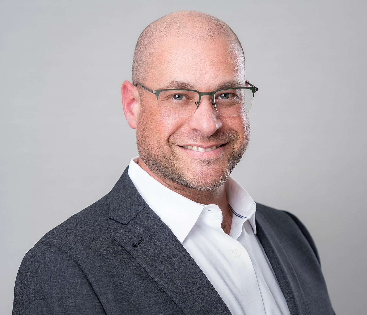 Smiling man in glasses and professional attire.