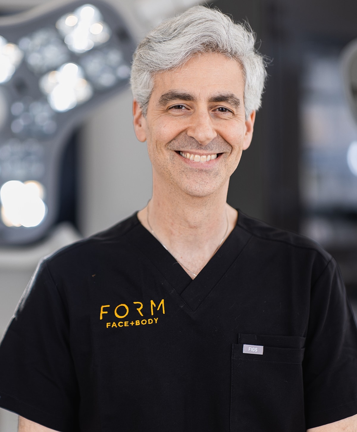 Smiling medical professional in black scrubs.