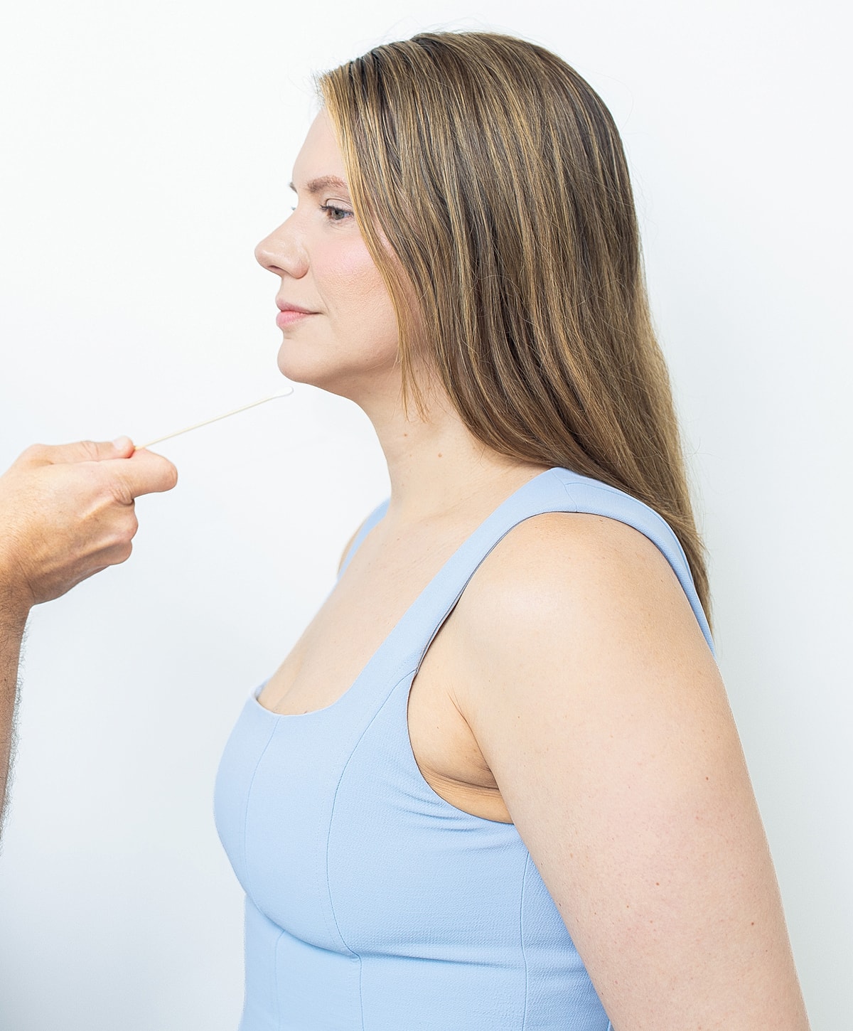 Profile view of woman with hair styling tool.