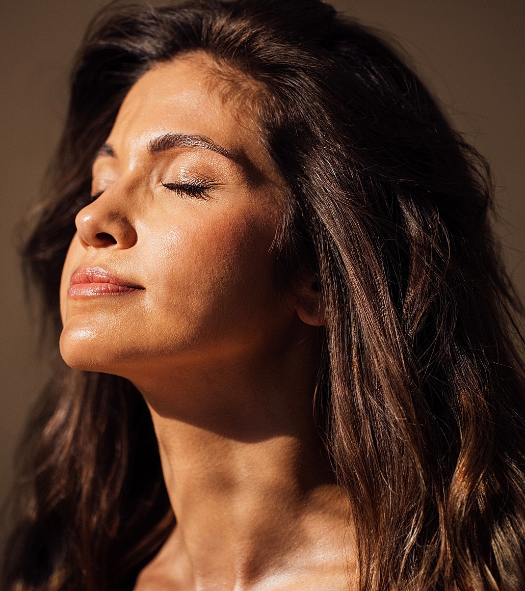 Woman with closed eyes enjoying sunlight.