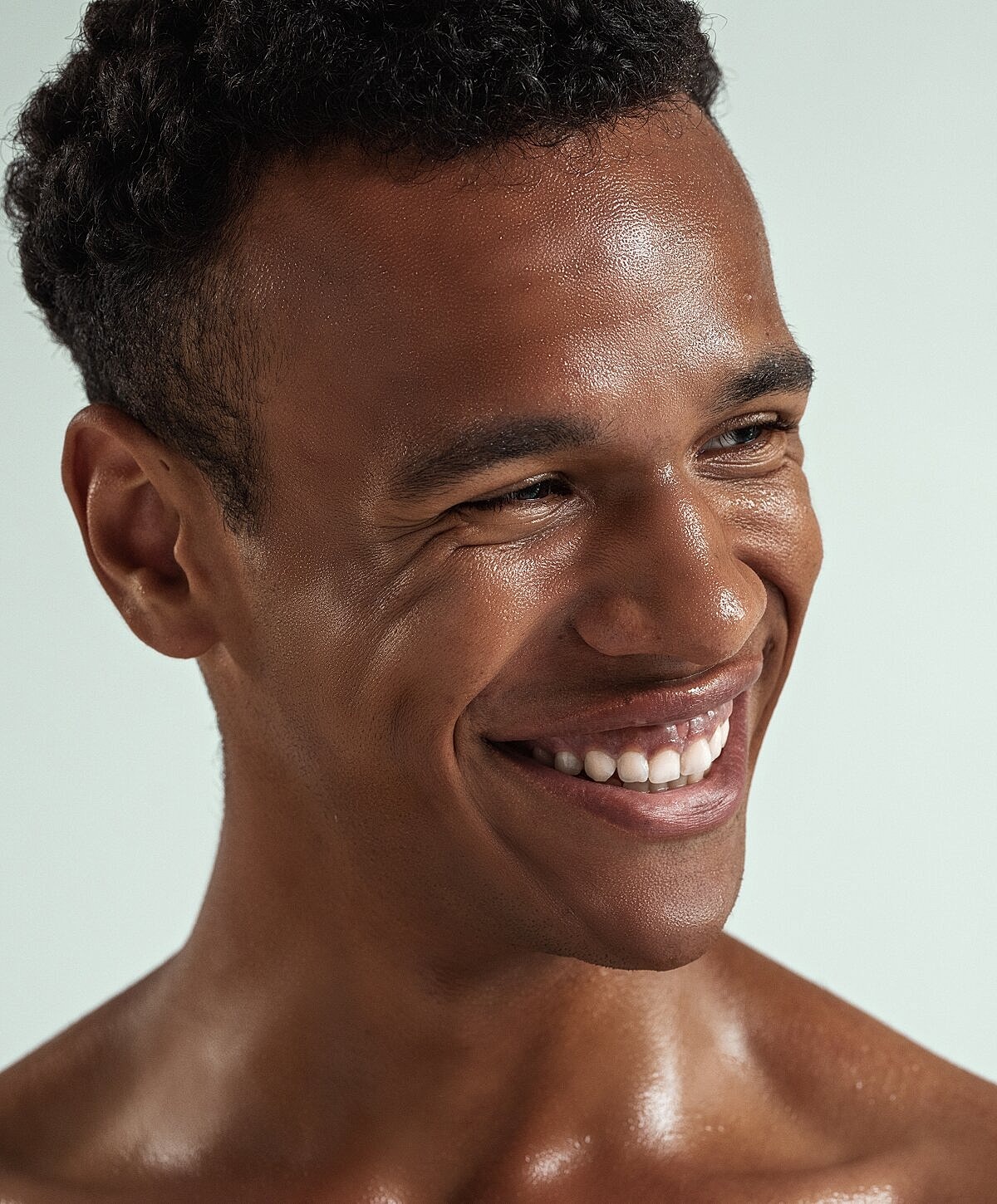 Smiling man with textured skin and short hair.