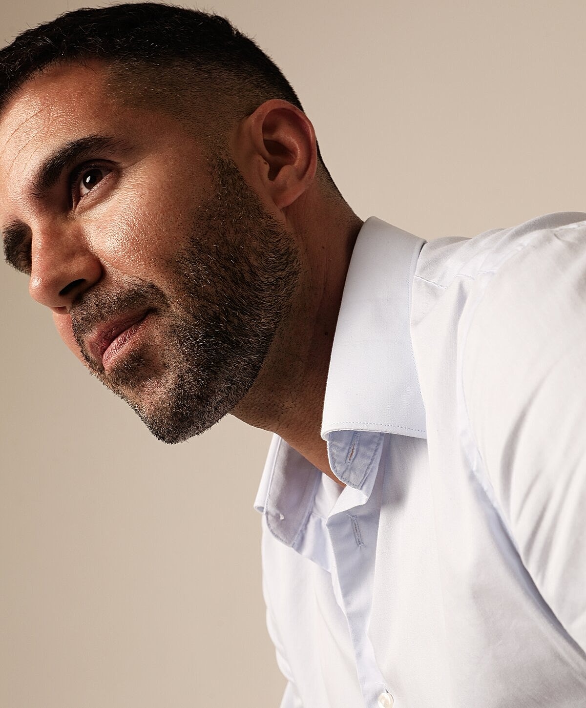 Man in light shirt with a thoughtful expression.