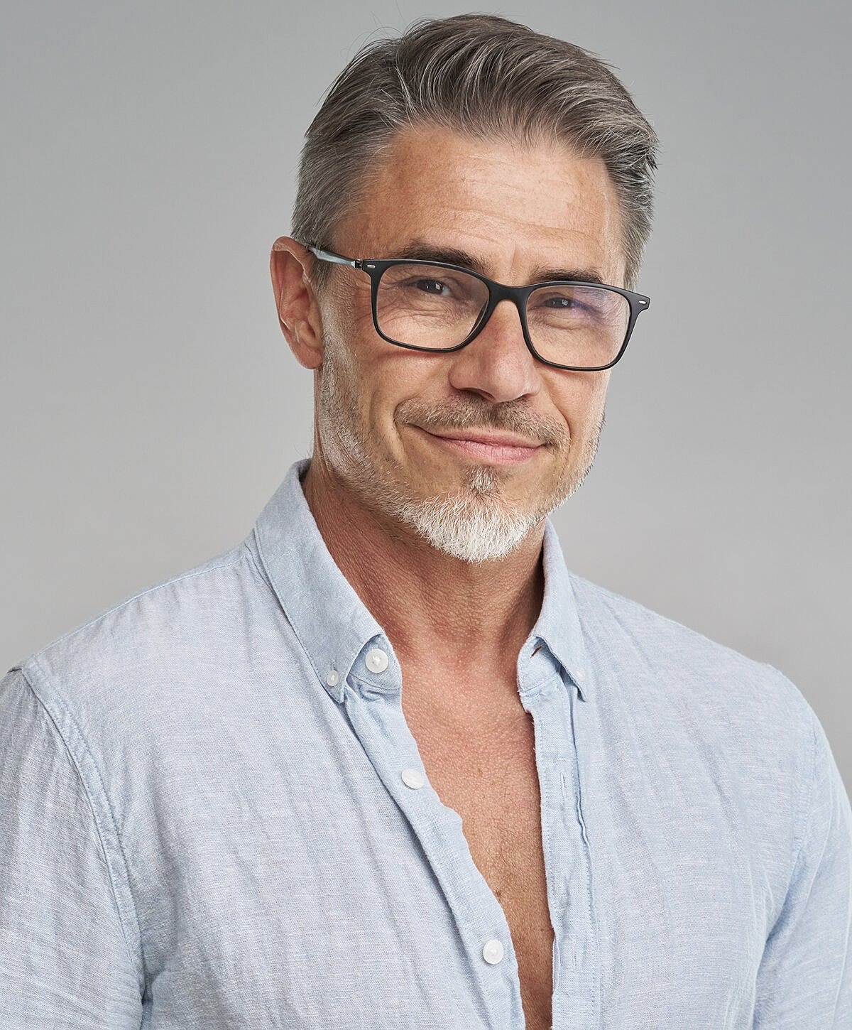 Smiling man with glasses in casual shirt.