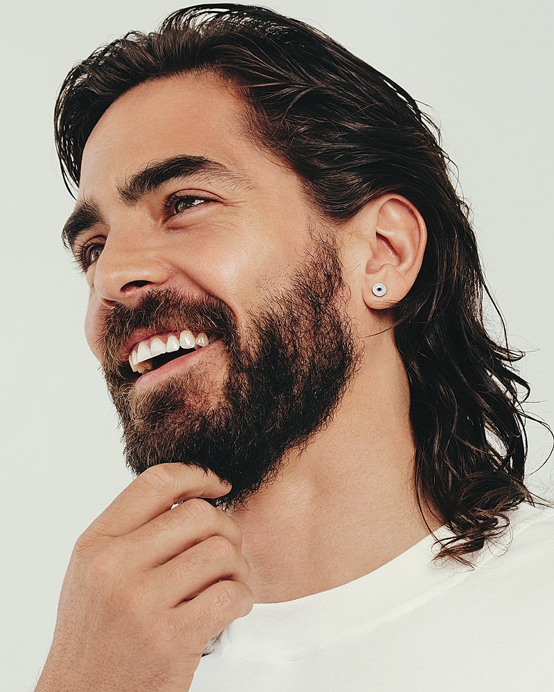 Smiling man with beard and long hair.