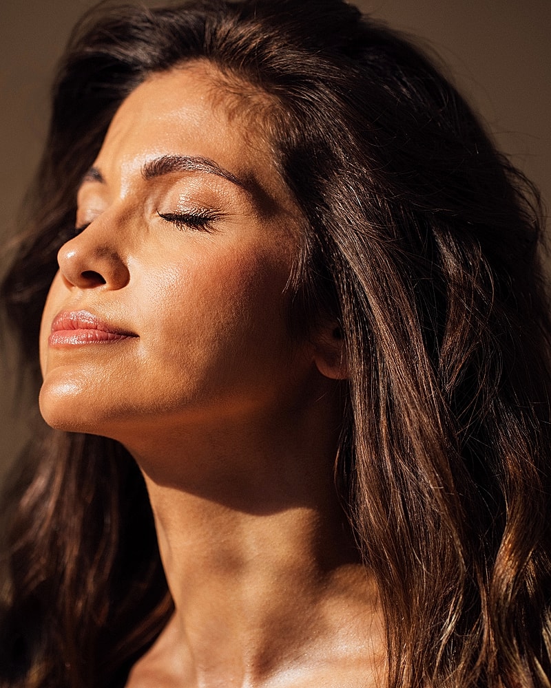 Woman enjoying sunlight with closed eyes.