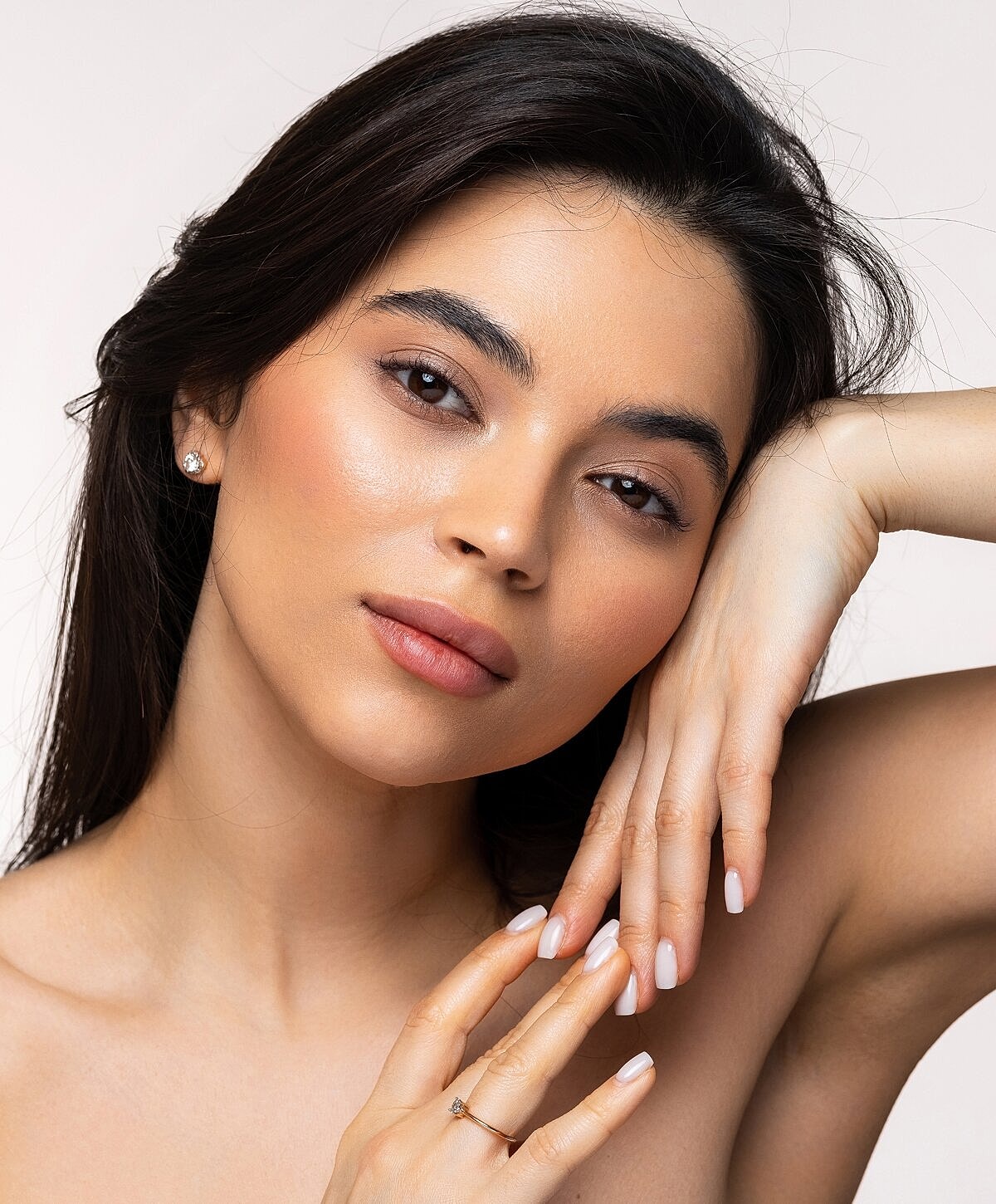 Woman posing with a serene expression and hands.