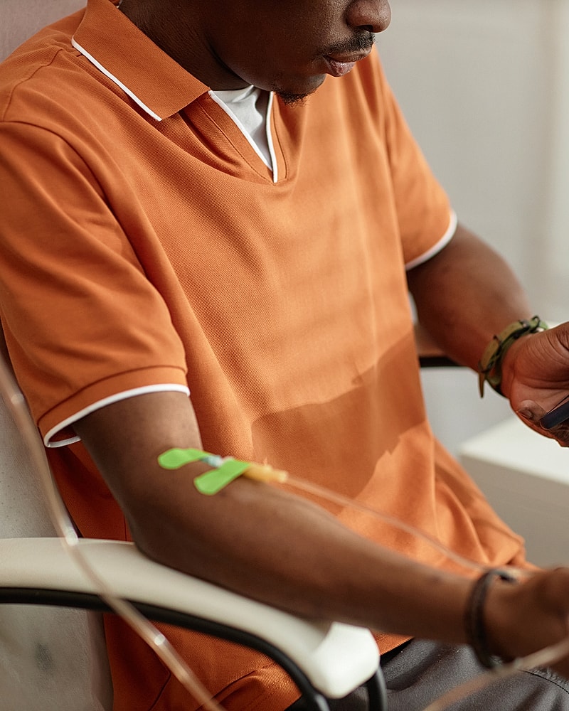 Person receiving treatment with IV in arm.