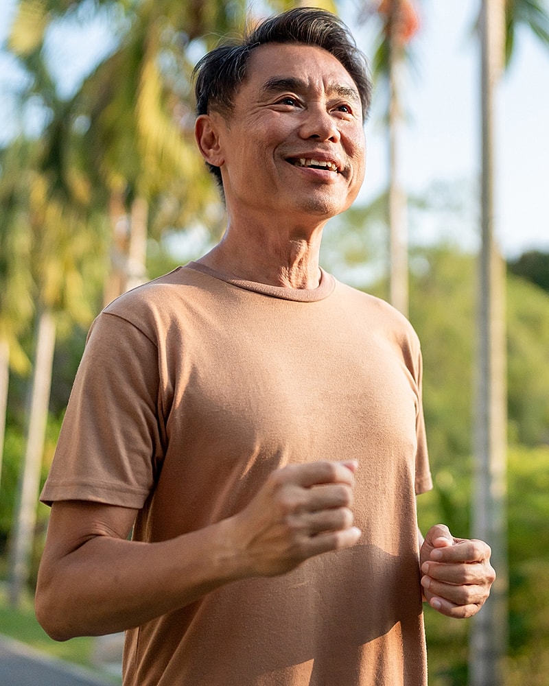 Man smiling while jogging outdoors.