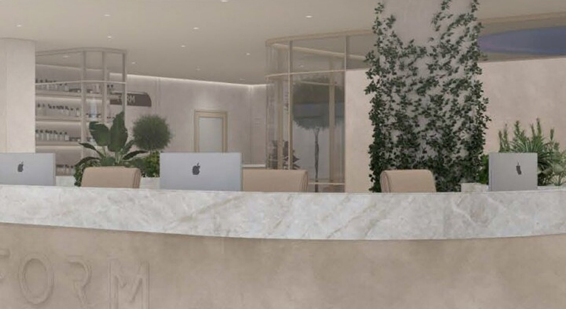 Modern reception area with computers and plants.
