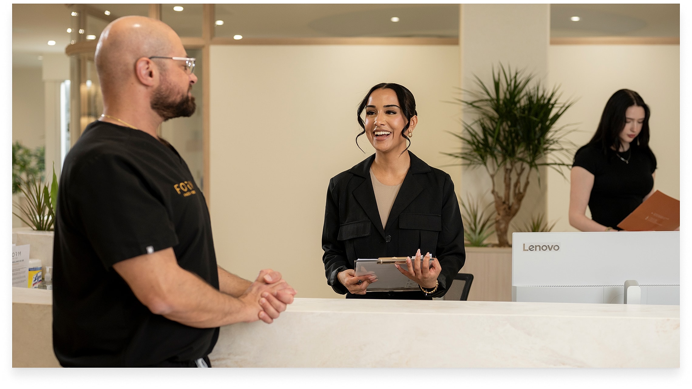 Receptionist assisting client in a modern office.