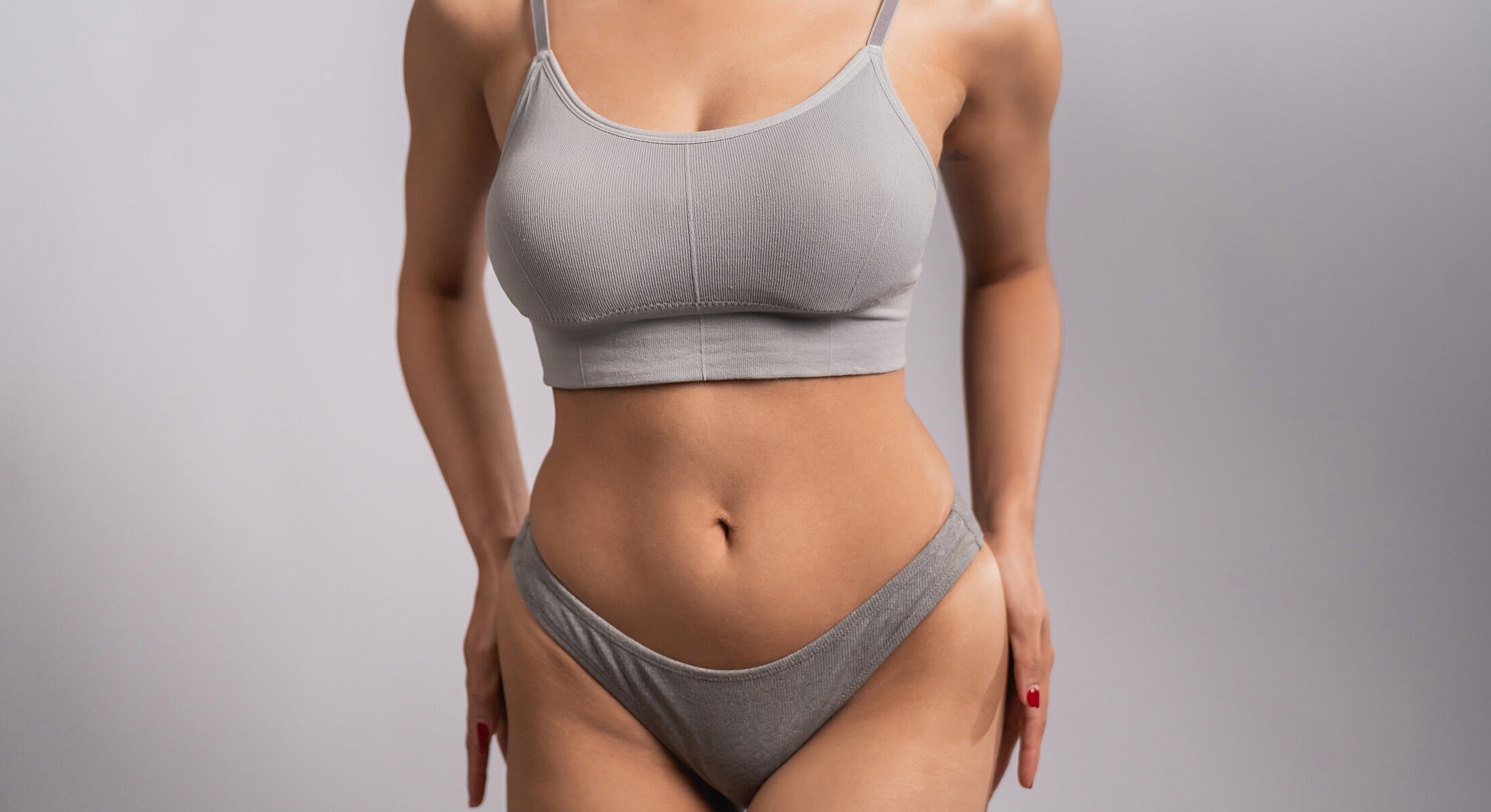 Model wearing gray sports bra and underwear.