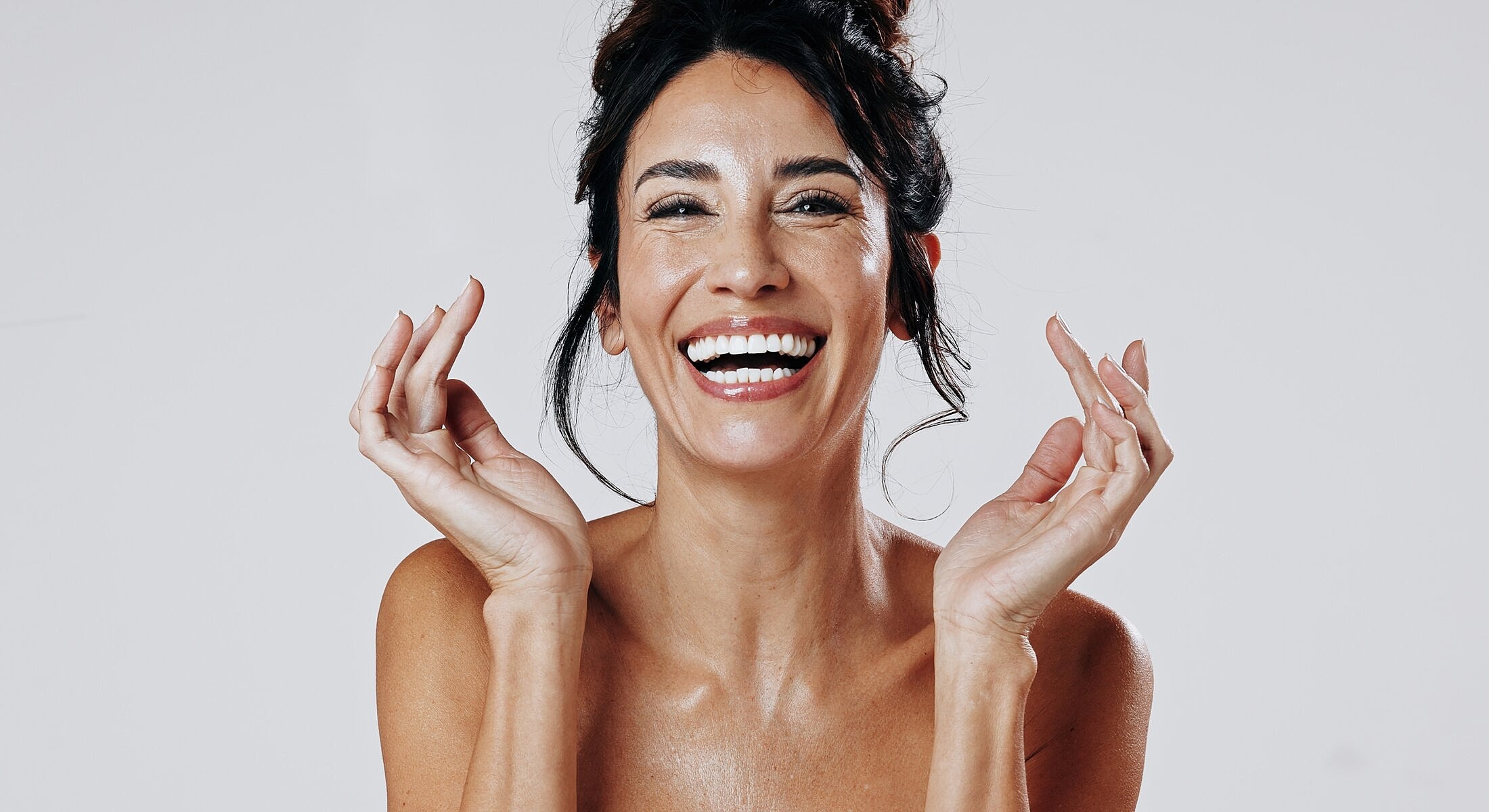 Smiling woman with hands raised joyfully.