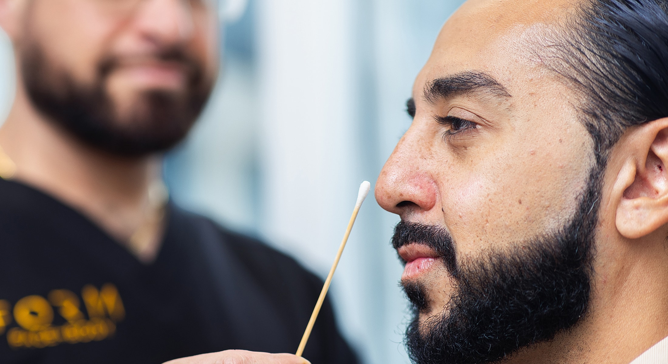 Toronto liquid rhinoplasty model receiving skincare treatment with cotton swab.