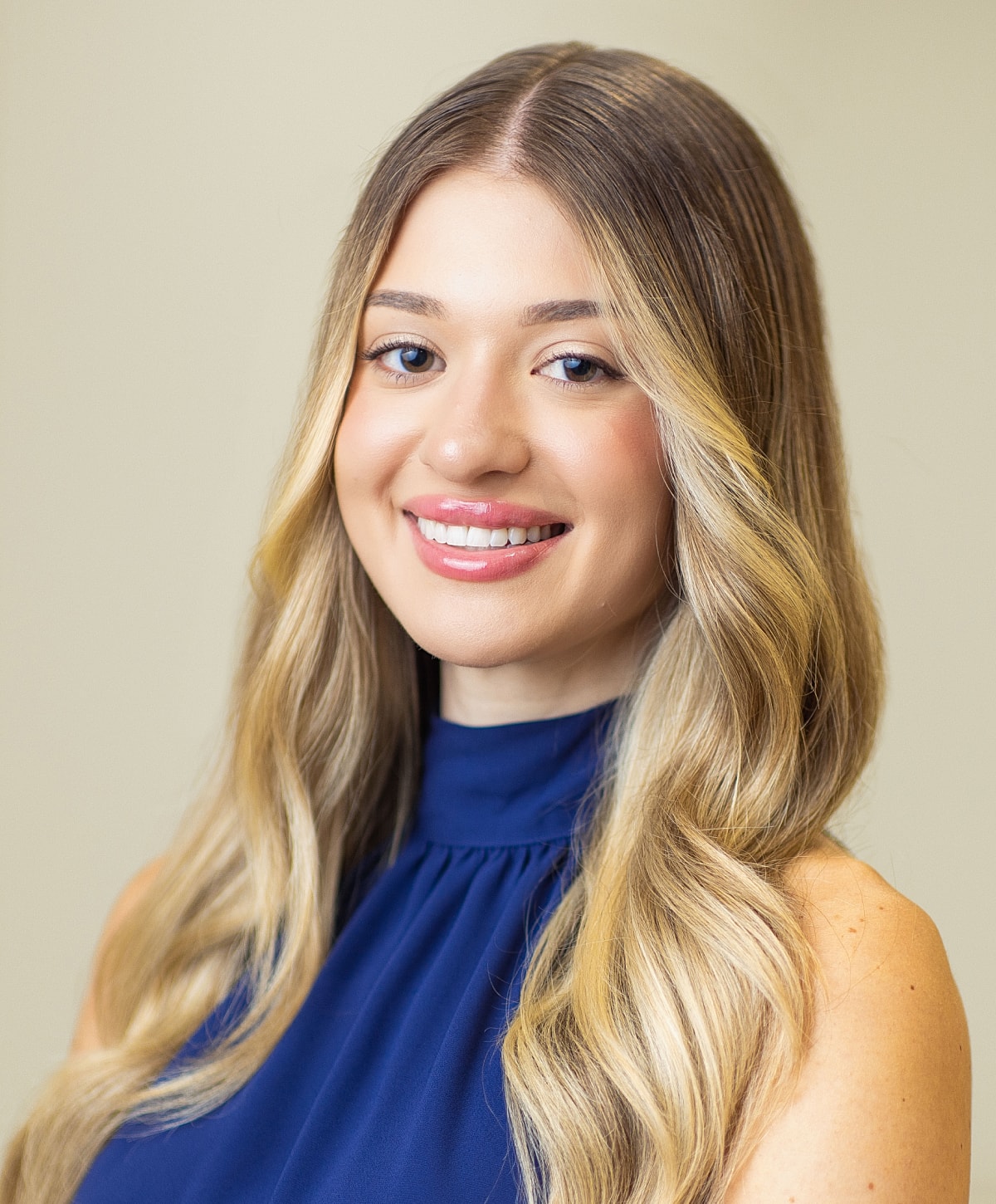 Smiling woman with long hair and blue eyes.